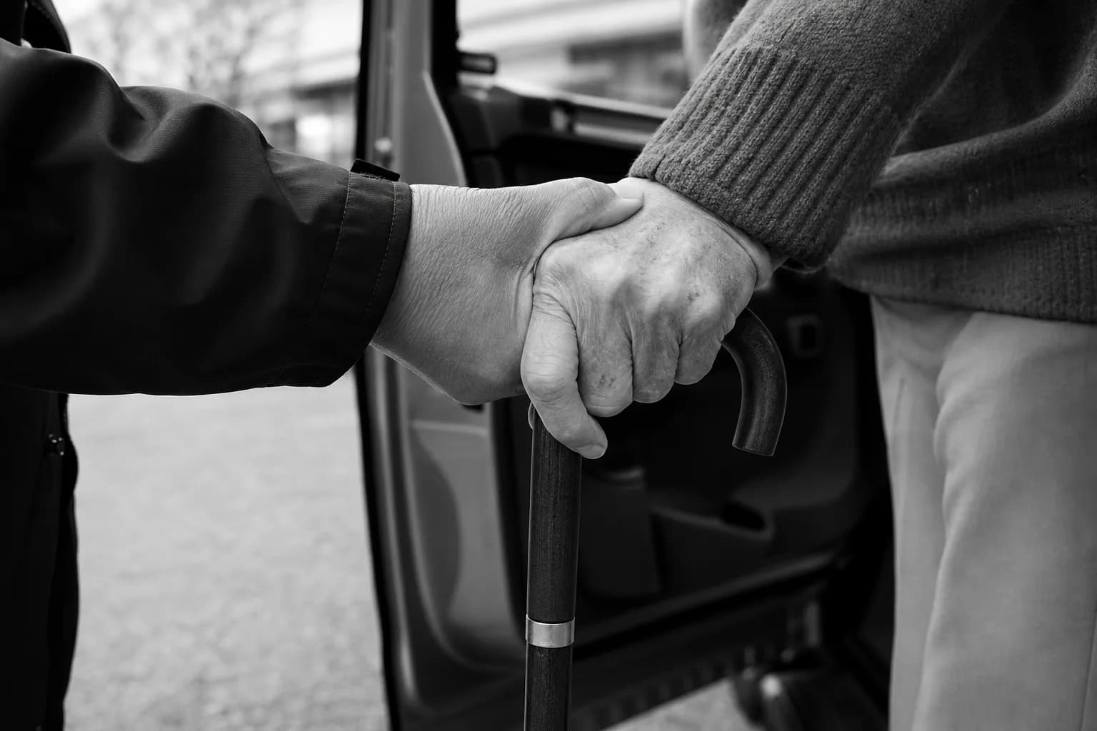 照顧者攙扶持拐杖的長者上無障礙接送車